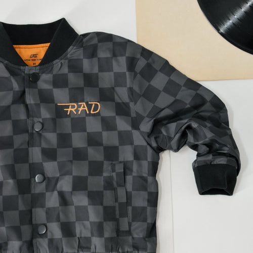 Children's waterproof letterman jacket by Little Rad Things with a checkers pattern, featuring a sporty and stylish design.