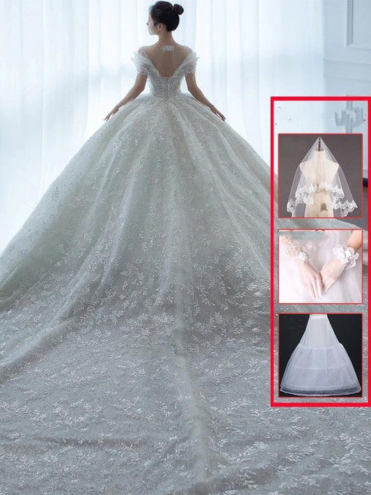 Off-shoulder French main wedding dress by MANDOTOS featuring elegant lace details and a flowing silhouette.