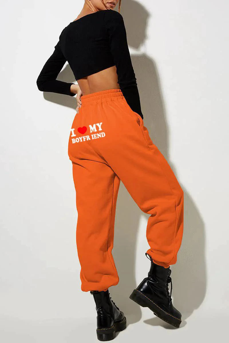Mandotos Chic Love Print Trousers featuring a stylish heart pattern, tailored fit, and vibrant design perfect for casual or trendy outfits.