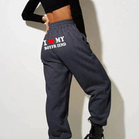 Mandotos Chic Love Print Trousers featuring a stylish heart pattern, slim fit, and comfortable fabric for casual or chic outfits.