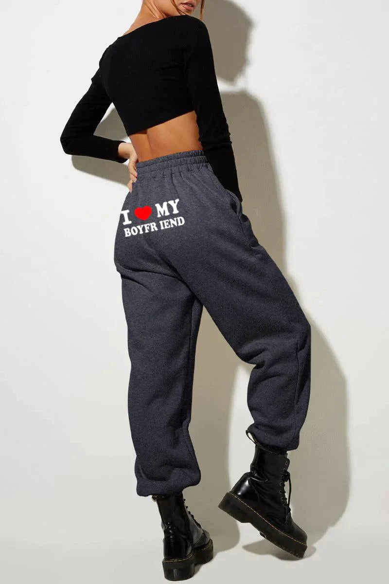 Mandotos Chic Love Print Trousers featuring a stylish heart pattern, slim fit, and comfortable fabric for casual or chic outfits.