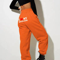 Mandotos Chic Love Print Trousers featuring a stylish pattern, fitted waist, and relaxed fit for casual and trendy wear.