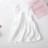 Toddler wearing a lightweight cotton sundress from MANDOTOS with floral patterns and ruffled straps.