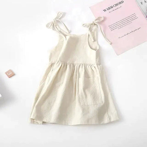 Toddler wearing a light blue cotton sundress with ruffle straps, designed by MANDOTOS, perfect for warm weather.