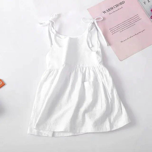 Baby girl wearing a white cotton chic toddler sundress with colorful floral patterns by MANDOTOS.