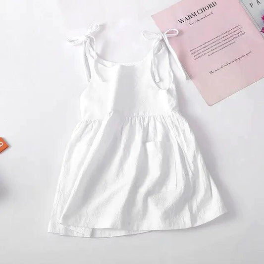 Baby girl wearing a white cotton chic toddler sundress with colorful floral patterns by MANDOTOS.