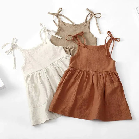 Toddler girl wearing a white cotton chic sundress by MANDOTOS, featuring a sleeveless design and floral accents.
