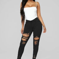 Mandotos denim pencil pants for women, slim fit, long trousers with ripped holes and stretch feet detail.
