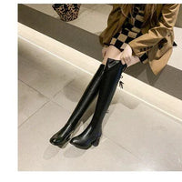 Elastic leather knee boots by MANDOTOS featuring a sleek design with stretch panels and sturdy heels.