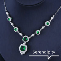 Mandotos Emerald Elegance white gold necklace featuring a central emerald gemstone and delicate chain design.