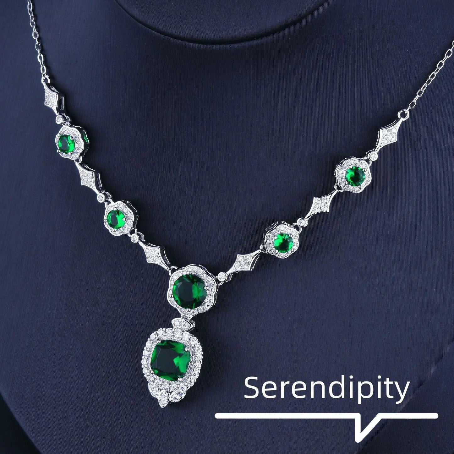 Mandotos Emerald Elegance white gold necklace featuring a central emerald gemstone and delicate chain design.
