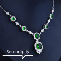 Mandotos Emerald Elegance white gold necklace with a central emerald gemstone and intricate gold detailing.