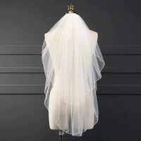 Ethereal double-tiered bridal veil by MANDOTOS featuring delicate lace edging and flowing sheer tulle layers.