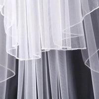 Ethereal double-tiered veil by MANDOTOS featuring delicate lace and sheer fabric, perfect for bridal or special occasion wear.