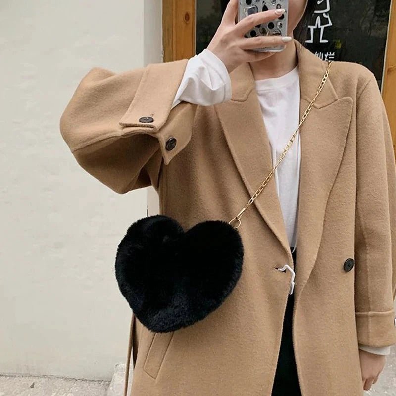 Mandotos women's heart-shaped faux fur crossbody bag with plush texture, chain shoulder strap, and tote-style design.