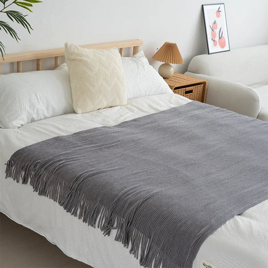 Knitted wool throw with tassels from MANDOTOS INTERNATIONAL, cozy home decor and travel blanket in soft, warm fabric.