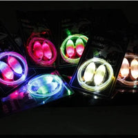 LED Light-Up Shoelaces by MANDOTOS glow in the dark, shown laced through sneakers with illuminated tips in a close-up shot.