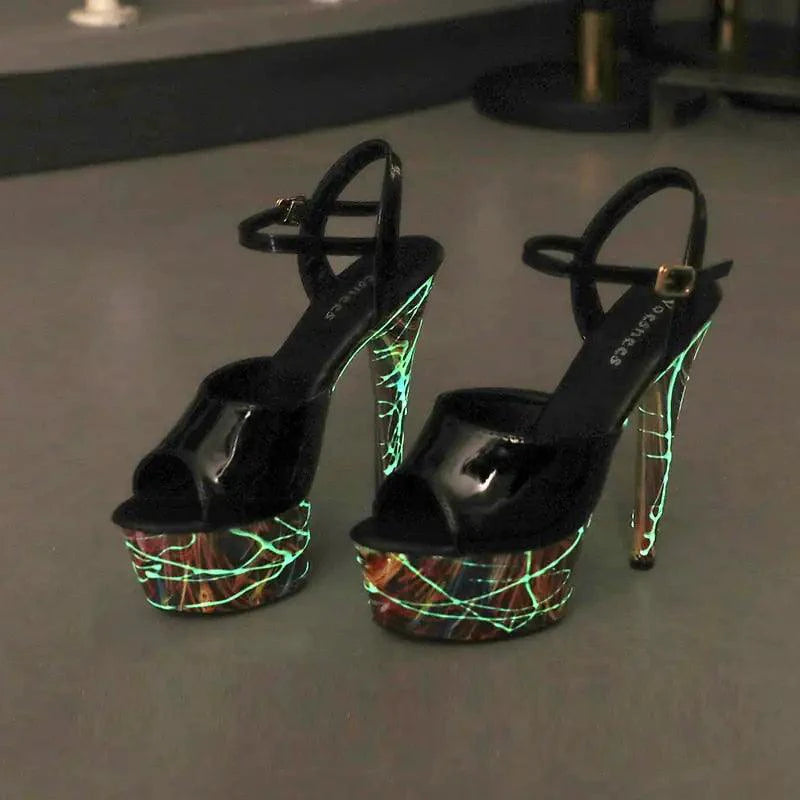 Pair of shiny black leather stilettos from MANDOTOS with pointed toes and high heels, showcasing elegant and polished footwear.