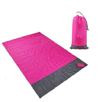 Mandotos sandproof portable beach mat spread out on sandy shore, lightweight and easy to carry for outdoor beach trips.