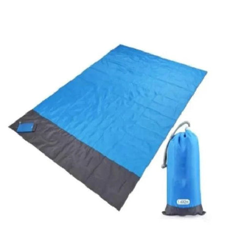 Mandotos sandproof portable beach mat laid out on sandy shore with ocean in background, lightweight and easy to carry for beach trips.