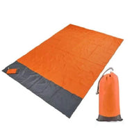 Mandotos sandproof portable beach mat spread out on sandy shore, lightweight and easy to carry for beach outings.