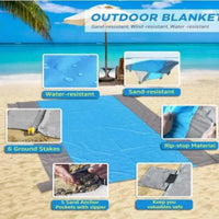 Mandotos sandproof portable beach mat laid out on sandy shore, showing its lightweight, foldable design for easy carrying.