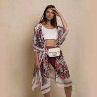 Mandotos Urban Blossom Kimono with floral pattern, lightweight fabric, and wide sleeves, displayed hanging on a wooden hanger.