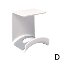 Plastic wall-mounted headphone stand and gaming headset holder with adhesive strip for under-desk earphone organization.
